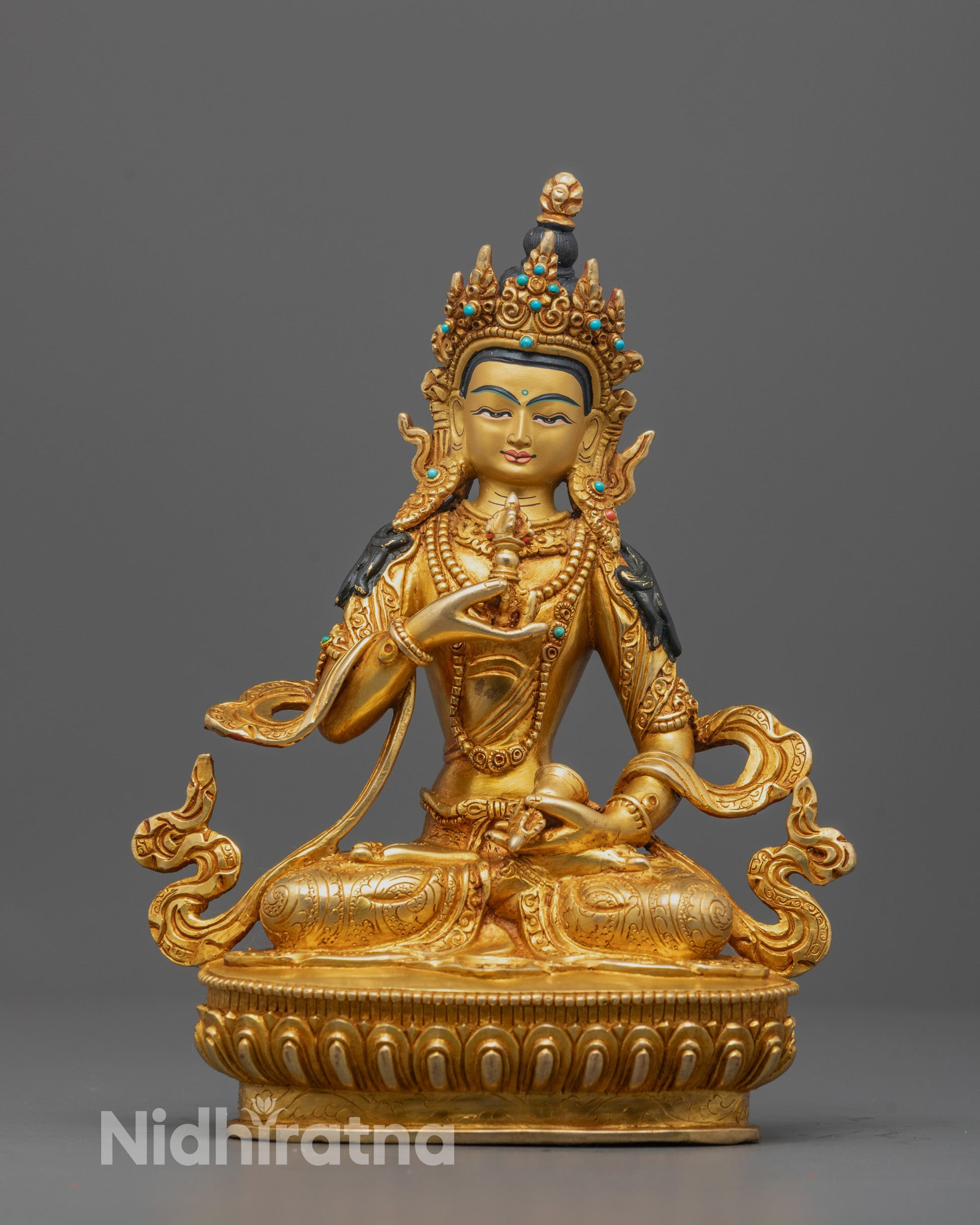 Front view of the Vajrasattva Statue seated on a lotus base while holding a vajra and bell
