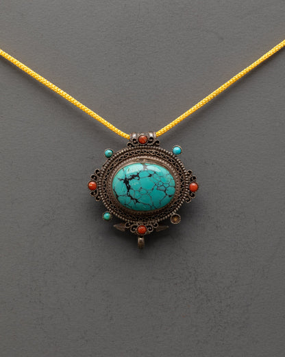 Front view of vintage Tibetan turquoise locket with copper filigree and gemstone inlay
