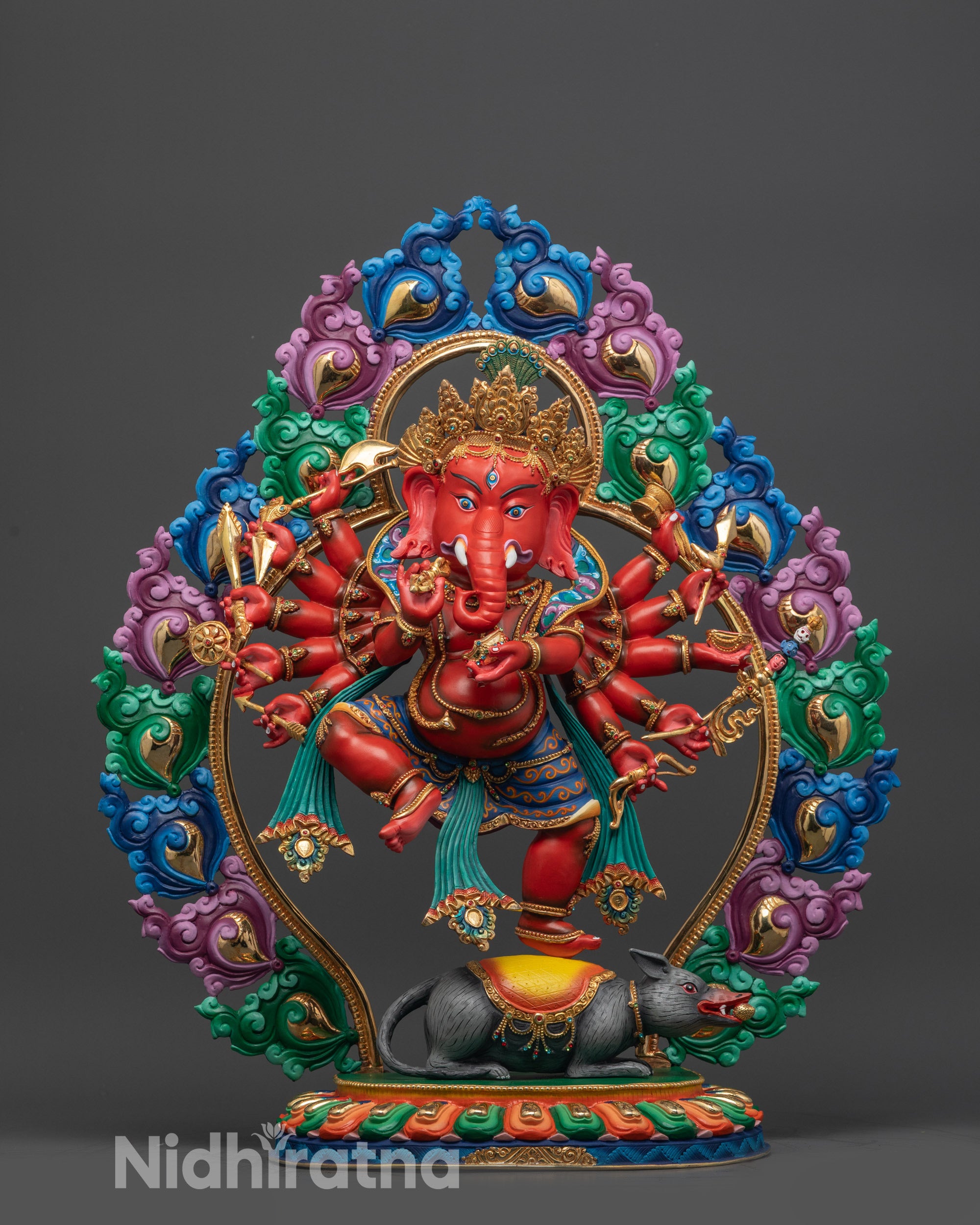 Front view red Ganesh statue with gold crown and halo on lotus seat

