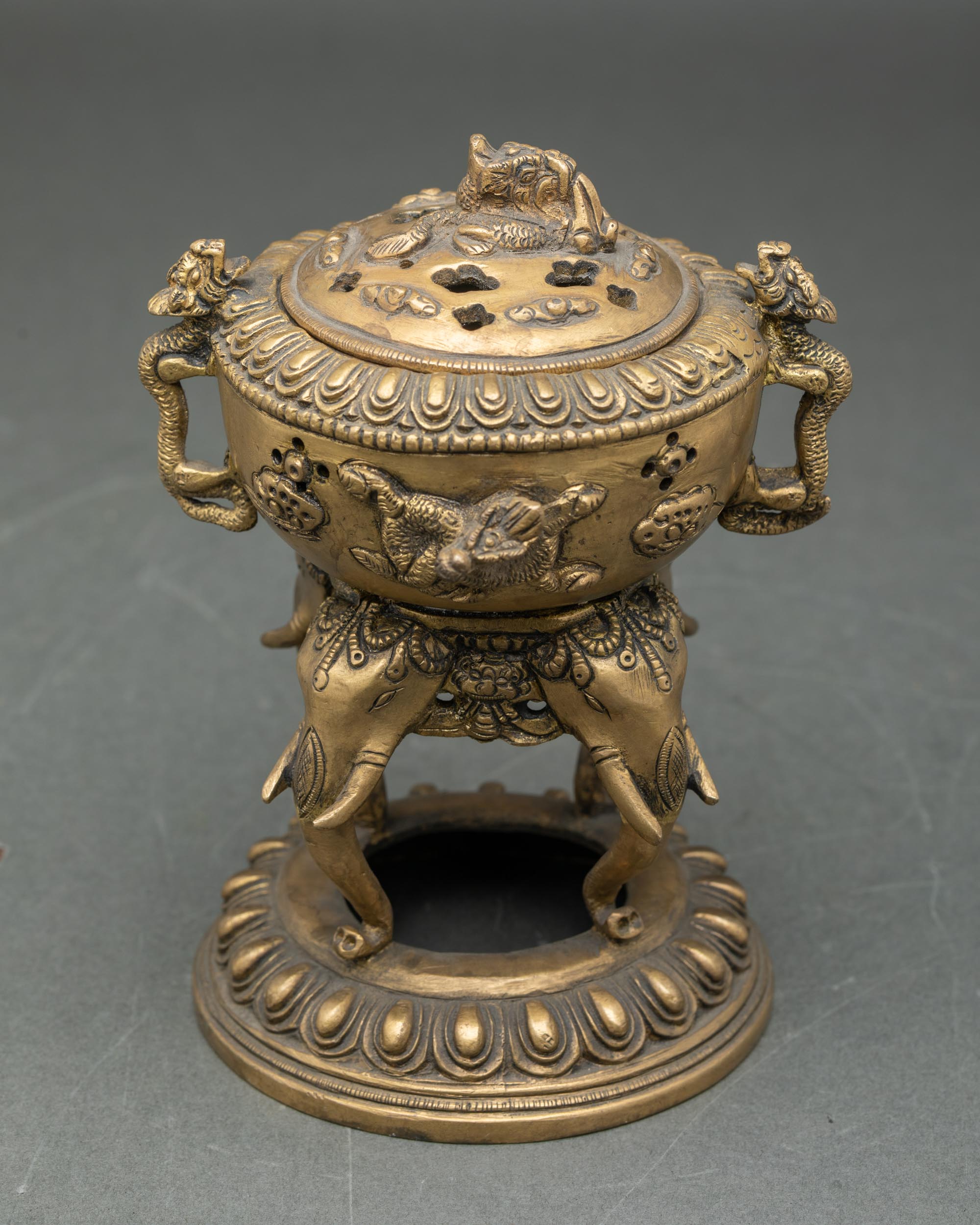 Full side profile of handmade brass dhoop burner with elephant trunk stand lotus seat Nepal