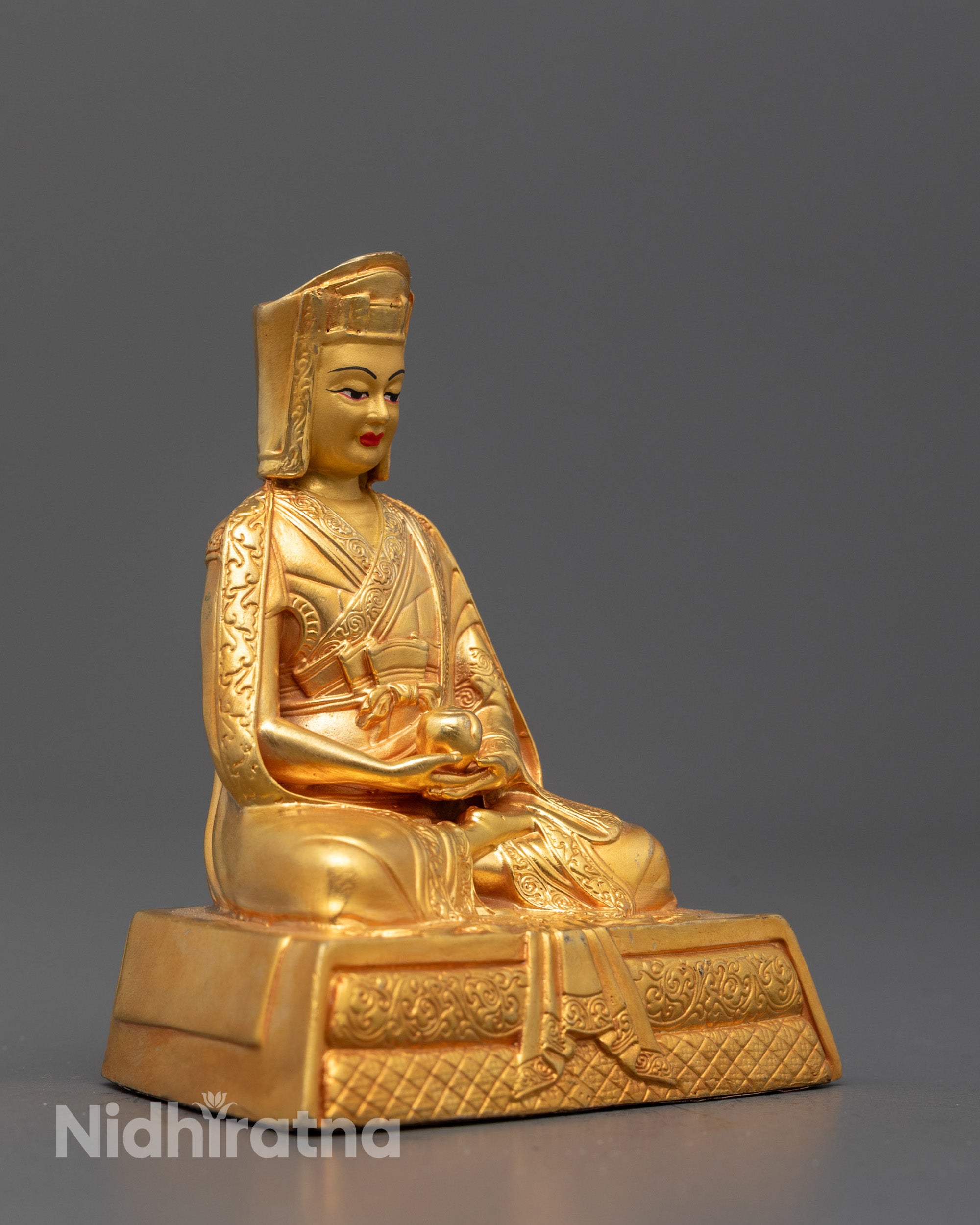 Full-body image of Gampopa Buddhist master statue placed on lotus base representing the founder
