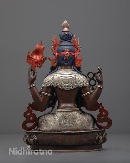 Oxidized Chenrezig statue on lotus base, showcasing silver plating, colorful accents, and sacred iconography from Nepalese craftsmanship."