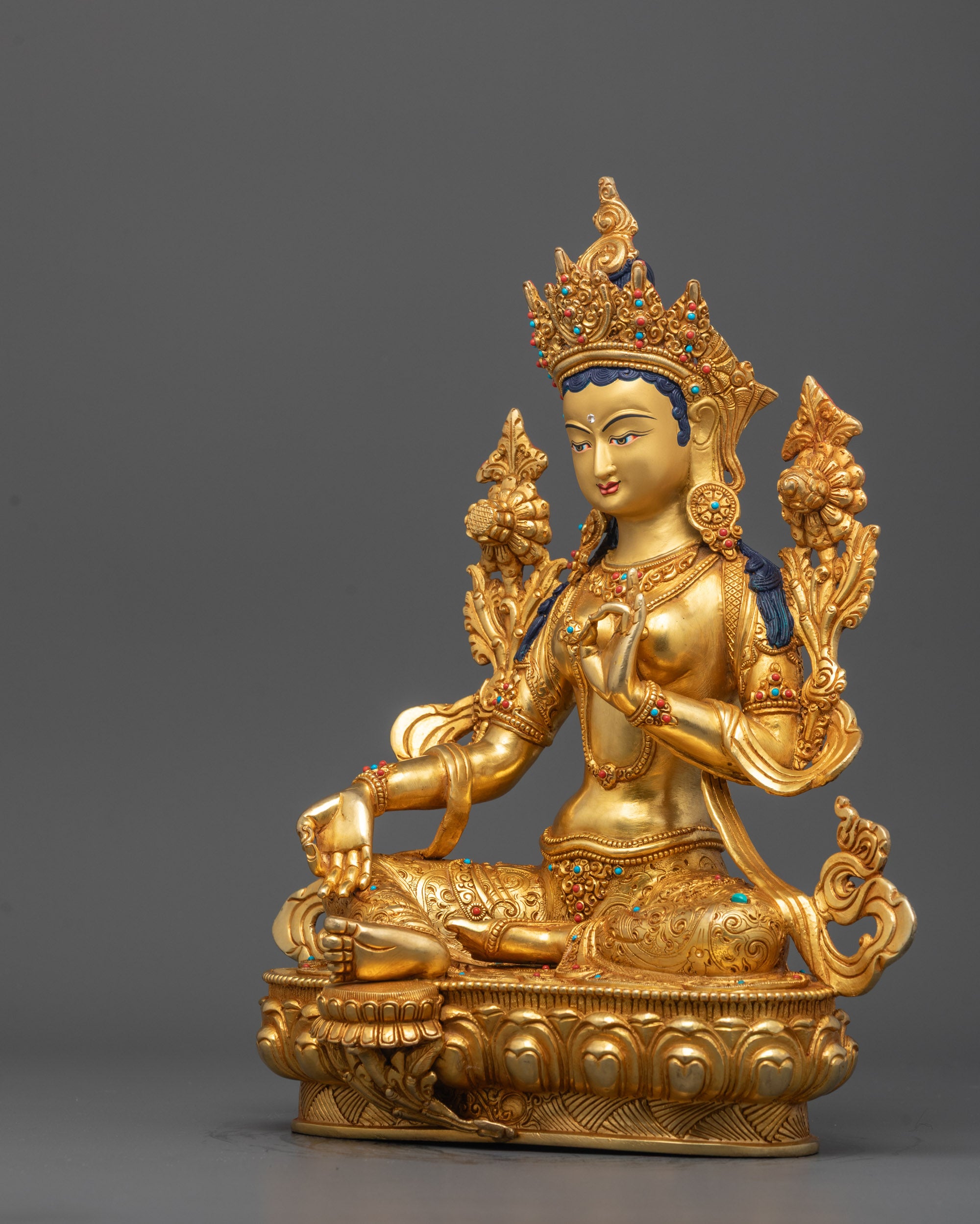 Full view of Green Tara statue holding lotus flower, crafted from copper