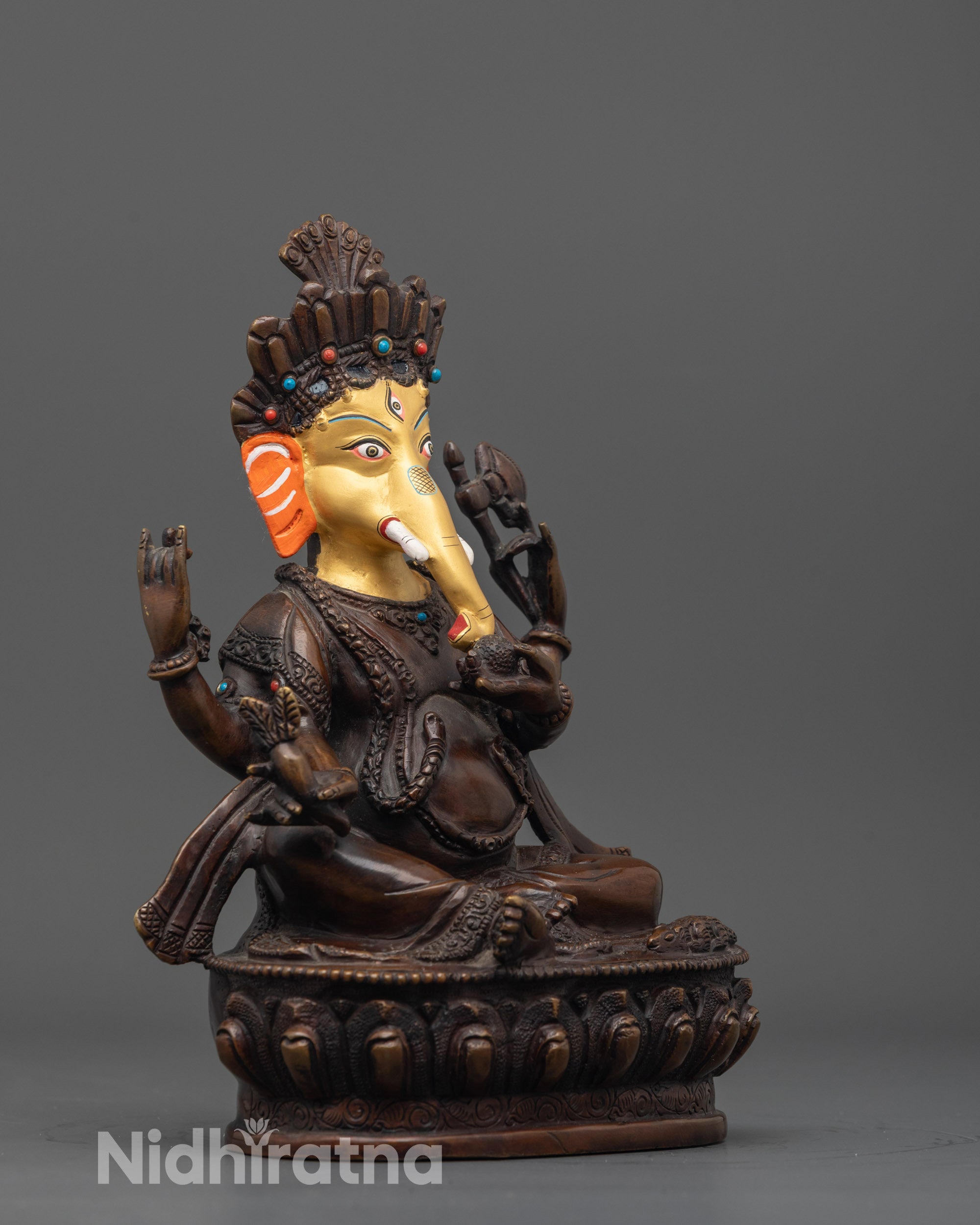 Side angle showing oxidized copper body and symbolic serpents on Lord Ganesha statue
