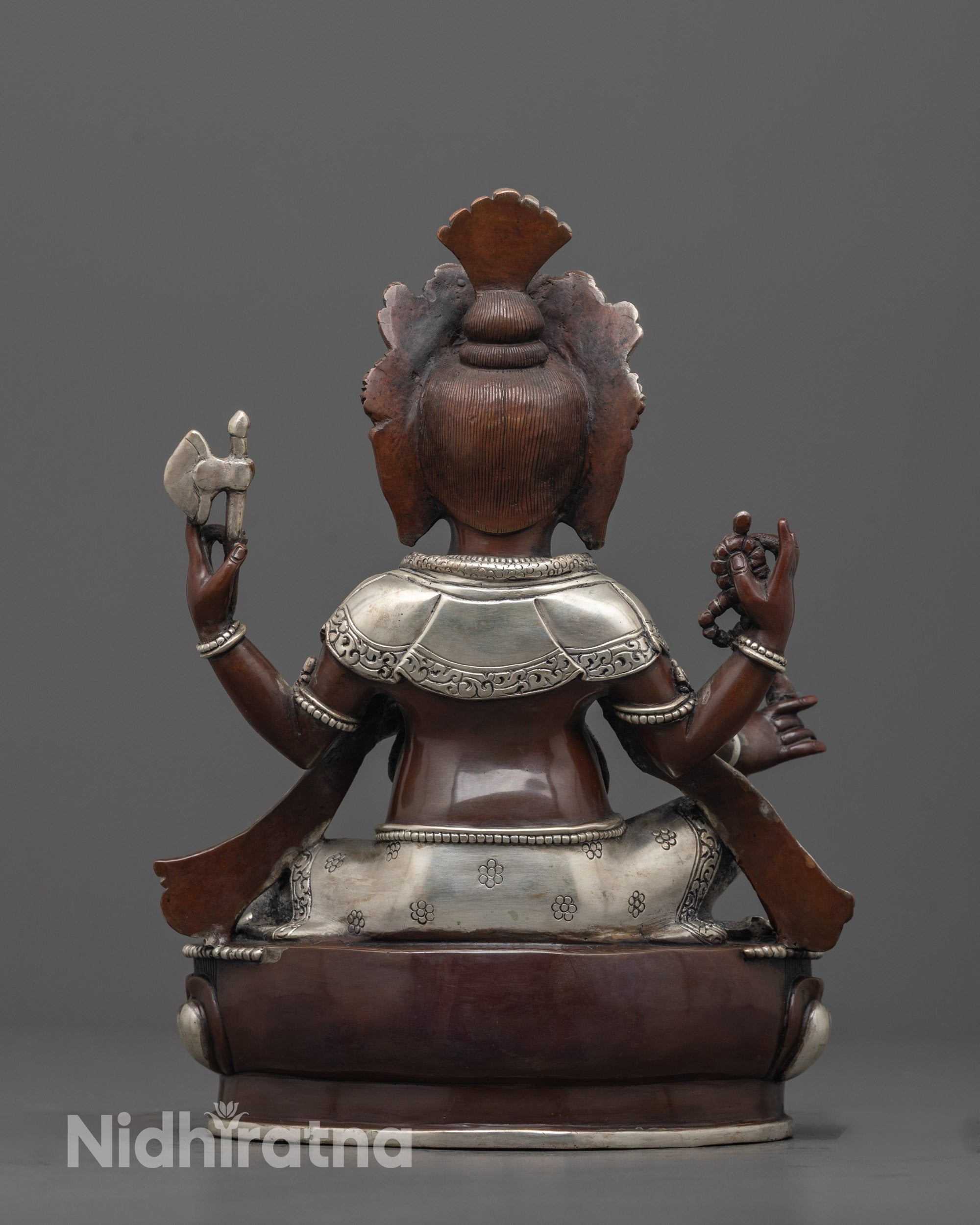 back view of silver-plated garments and lotus base of traditional ganesha deity sculpture
