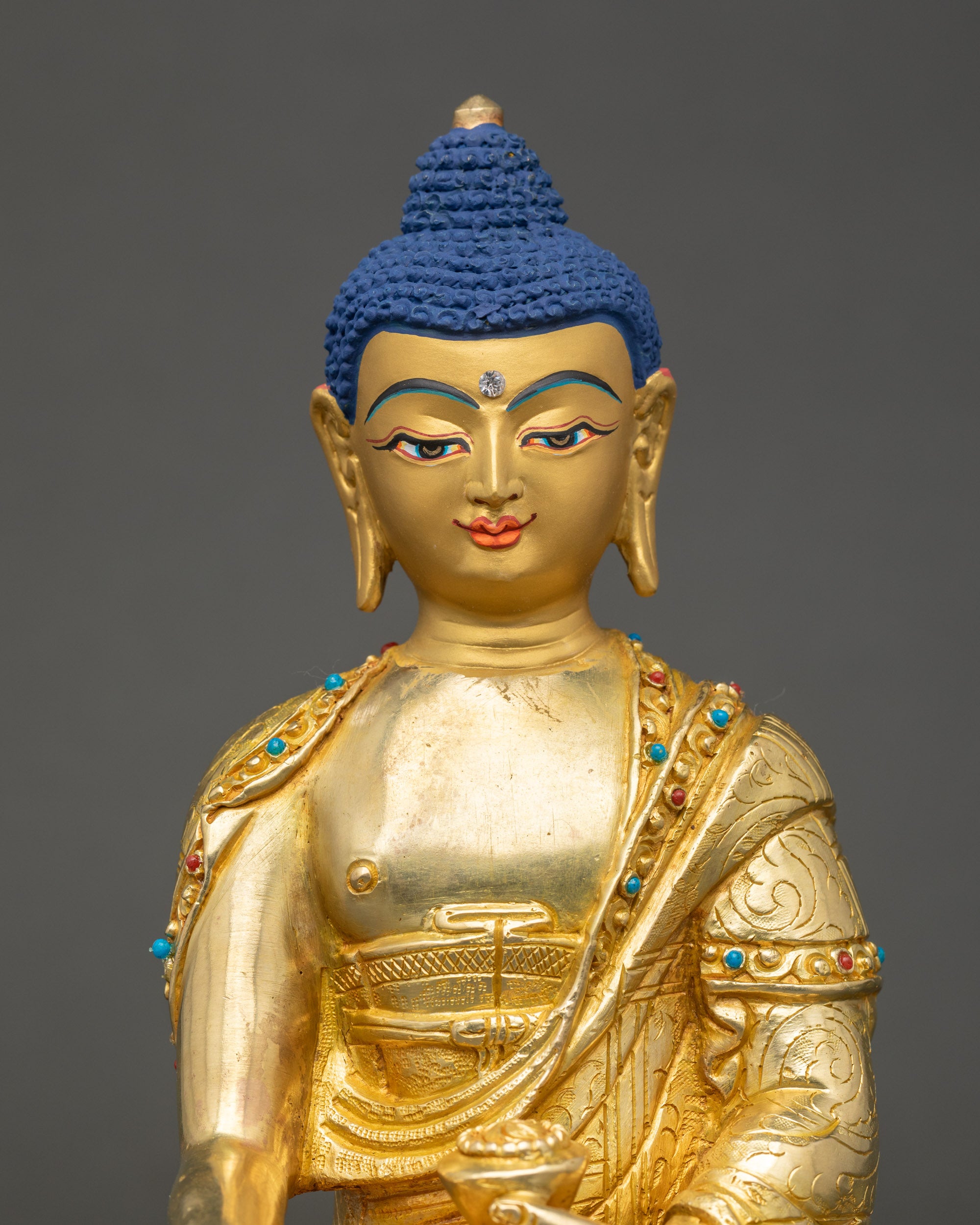Gautama Buddha Statue close up showing serene gold-gilded face and details