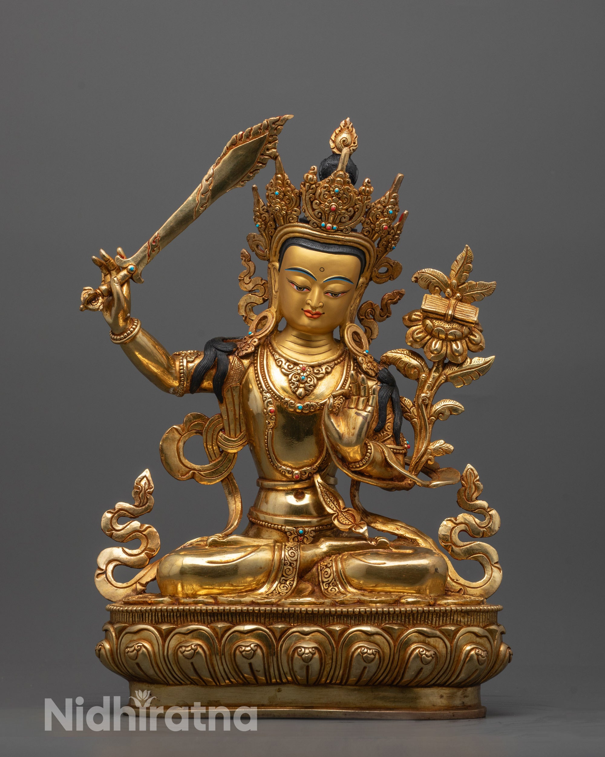 Gold-colored statue of a deity with a weapon on a gray background