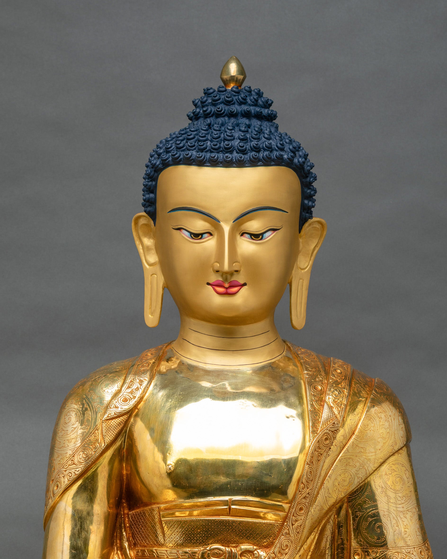Gold fire-gilded Shakyamuni Buddha statue showing robes with floral scrollwork and lotus motif carvings