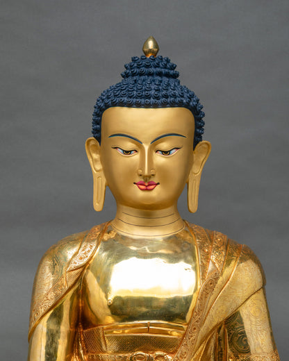 Gold fire-gilded Shakyamuni Buddha statue showing robes with floral scrollwork and lotus motif carvings