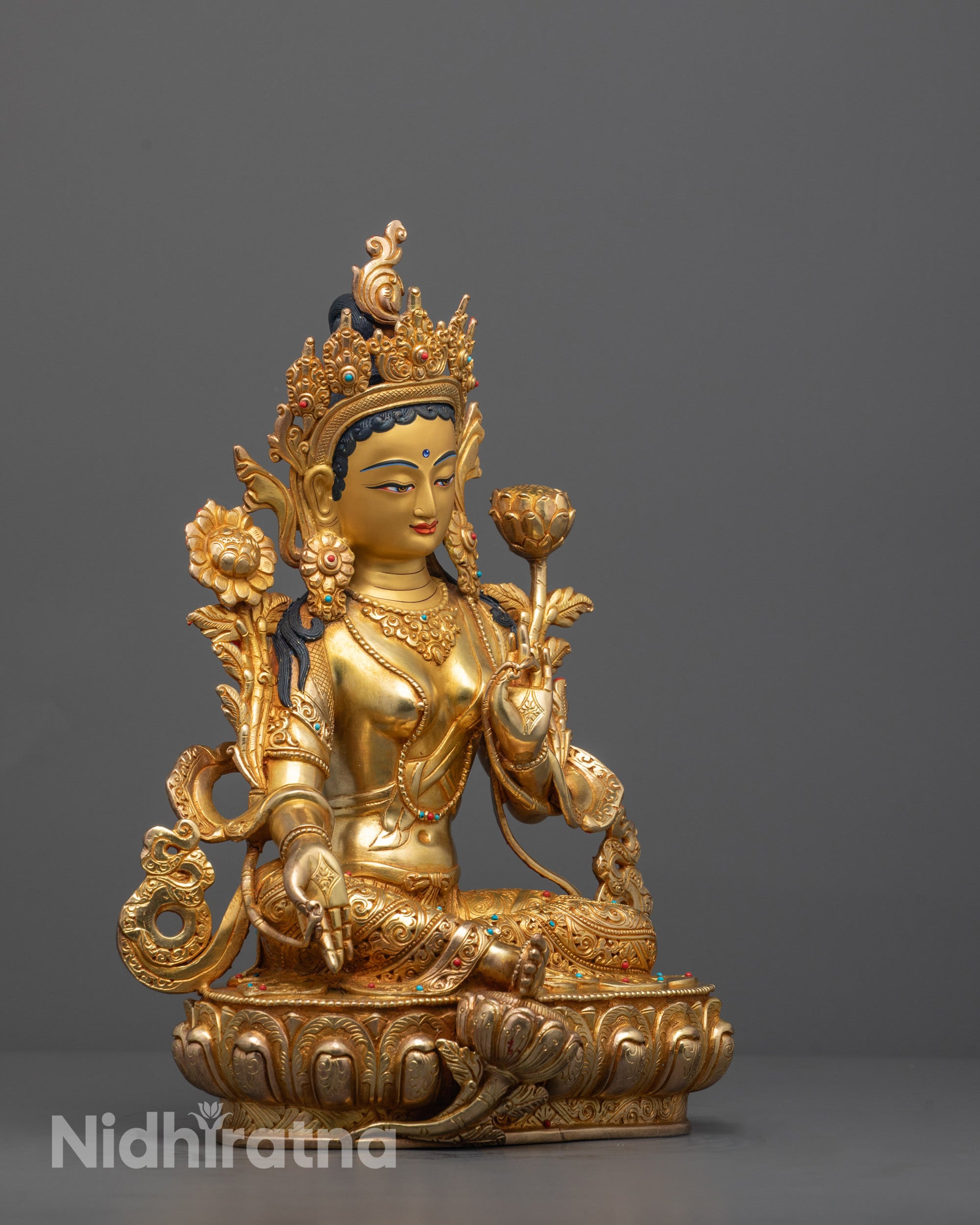 Side view of traditional Nepalese Green Tara Statue polished with gold and mercury