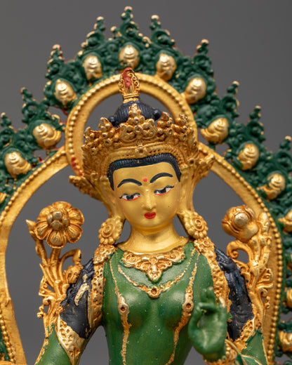 Detailed carving of jewelry crown robe and Uptala flowers on green Tara Buddhist statue with green halo