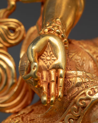 Close-up of a gold statue with detailed hand and bodywork against a dark background