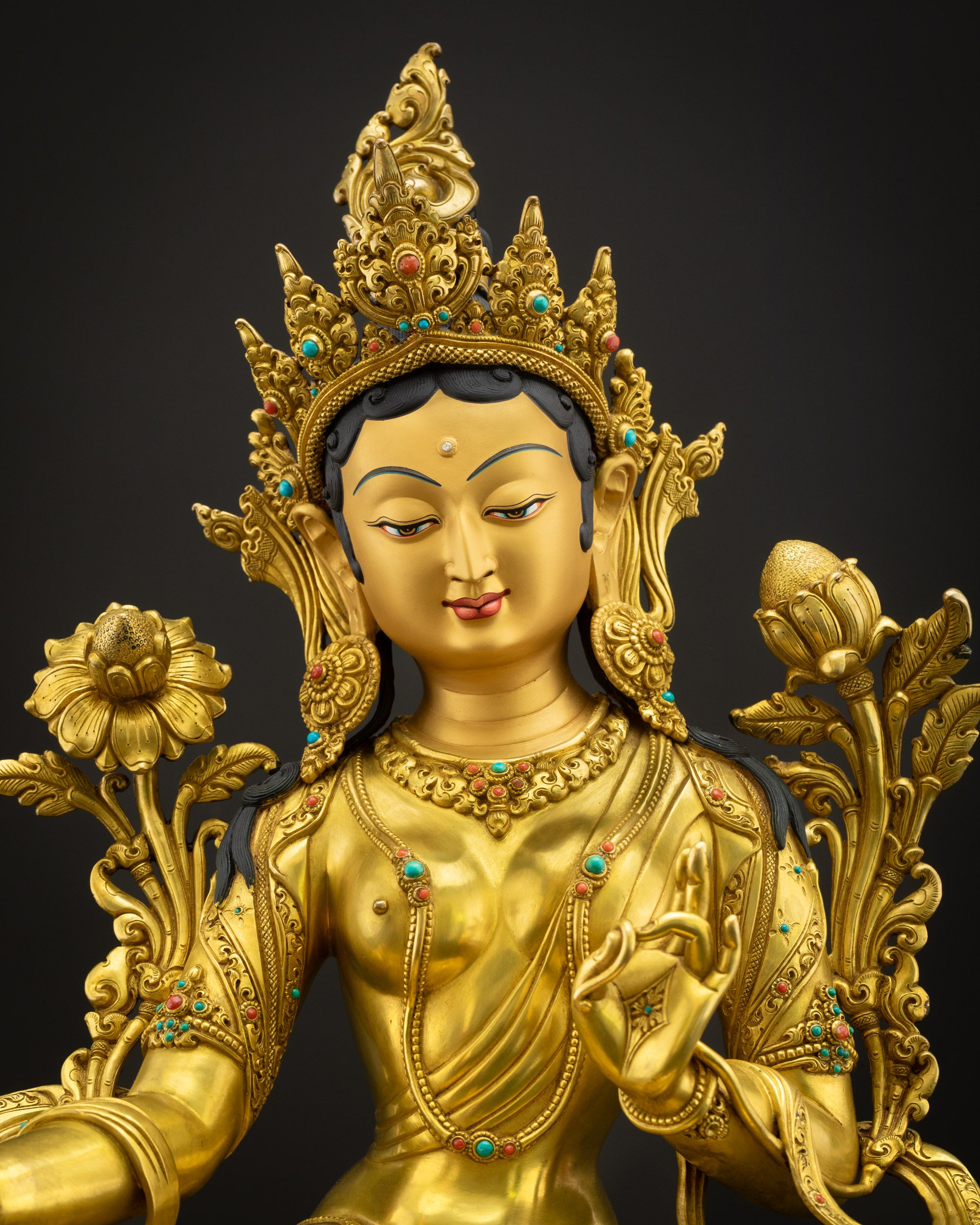Close-up of Green Tara Buddha statue showing detailed carvings, copper craftsmanship, and polished gold finish