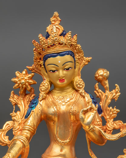 Green Tara Statue close up face with serene gold-painted expression Himalayan art