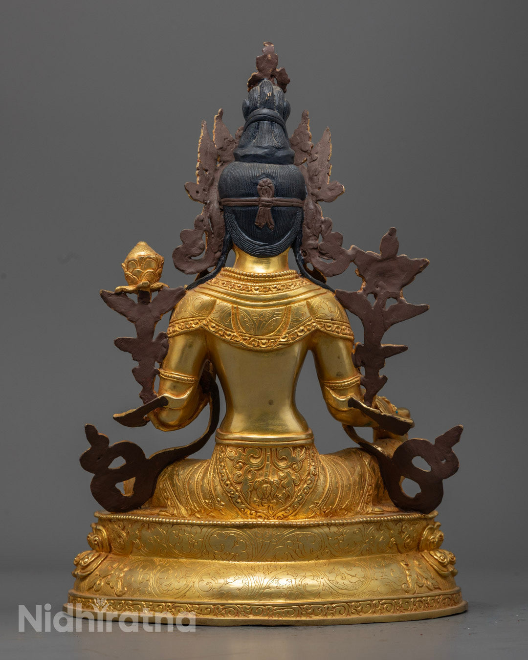 Green Tara Statue holding a blue lotus, symbolizing purity and compassion, adorned with semi-precious stones.