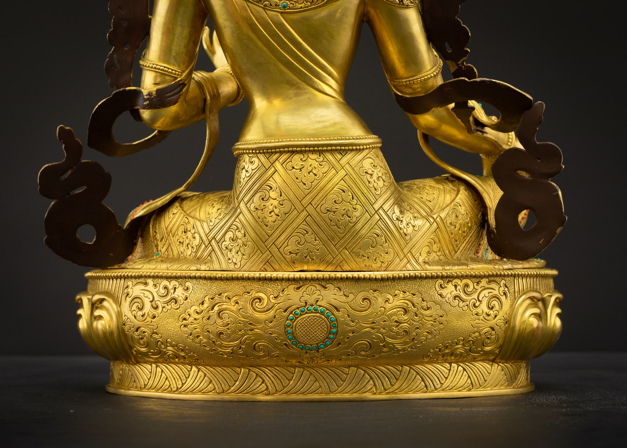 Lower back landscape view of Green Tara Tibetan statue showing intricate carvings and fire-gilded gold finish