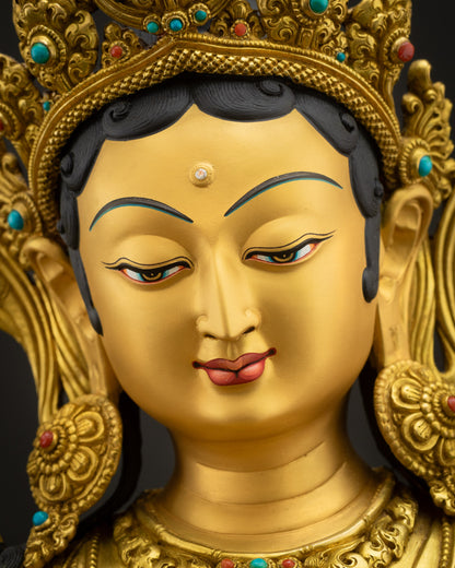 Detailed close-up of Green Tara Statue's face, serene expression, gold-painted face, semi-precious stone diadem