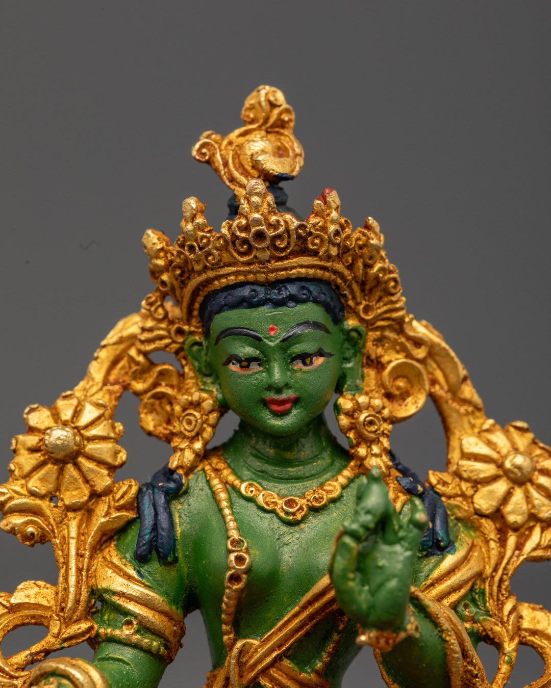 Green Tara sculpture featuring detailed carvings on jewelry, five-jeweled crown, and flowing robe symbolizing compassion and blessings