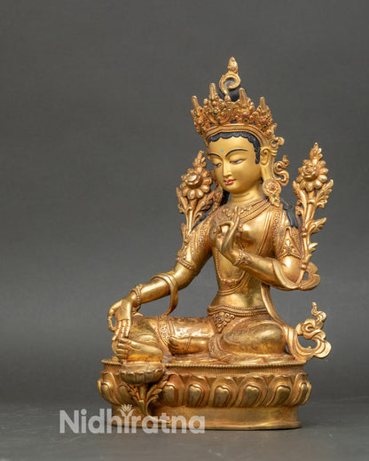 Green Tara seated on double lotus throne, holding utpala flower, gold-painted copper statue