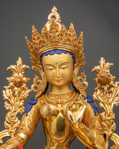 Green Tara statue close up showing detailed copper carvings and polished surface