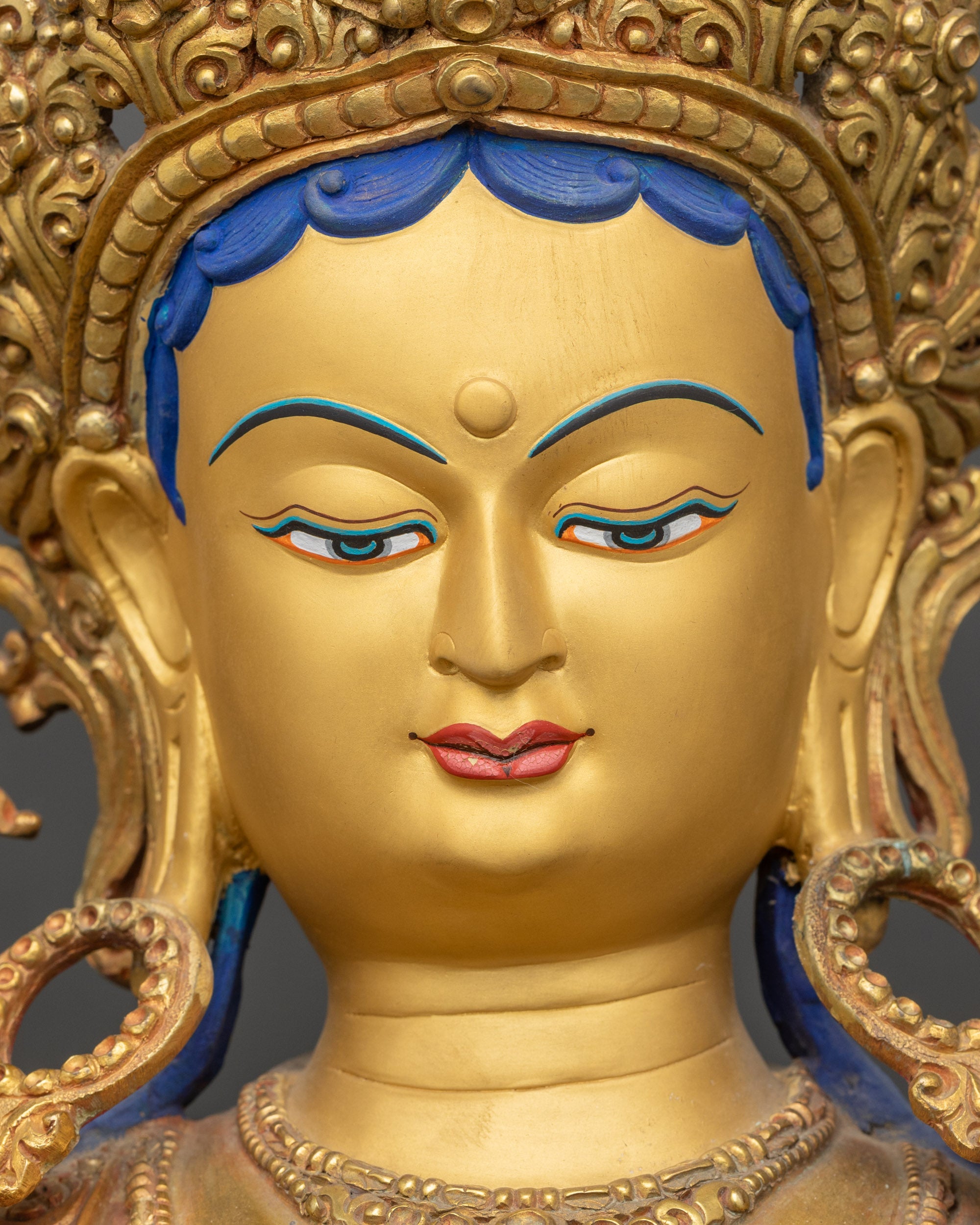 Green Tara statue detailed close-up face, serene expression with gold-gilded features