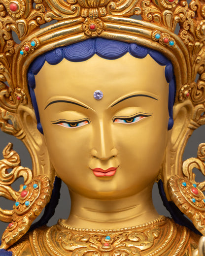 Green Tara statue face close up with gold painted expression and serene gaze