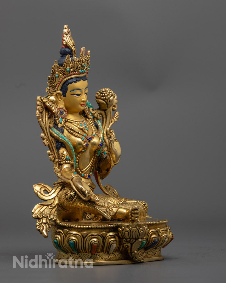 Green Tara statue highlighting extended leg posture, symbolizing swift compassionate action and divine readiness.