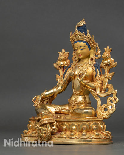 Green Tara statue left side view, intricate carvings on crown and robe visible