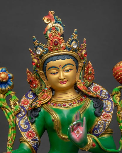 Green Tara statue regular close up showing gold painted face and ornate colorful robe