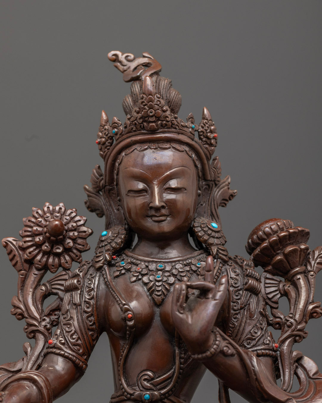 Green Tara statue’s flowing robe and intricate crown painted in vibrant acrylic color