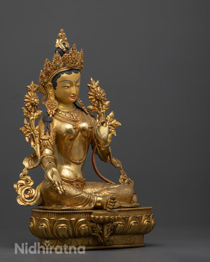 Green Tara statue seated gracefully on a lotus thorn with one leg extended in a gesture of readiness to help, holding an Utpala flower that represents purity