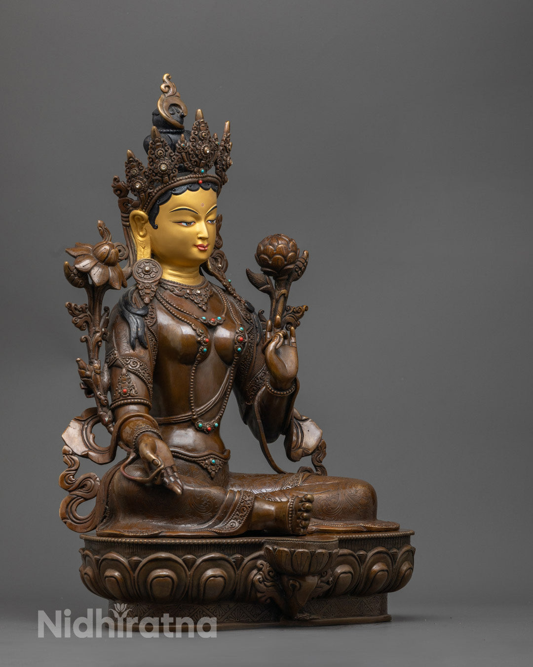 Green Tara statue showing intricate robe details and lotus throne carving