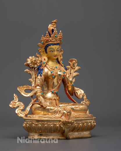 Side angle of Nepalese Green Tara statue holding utpala flowers