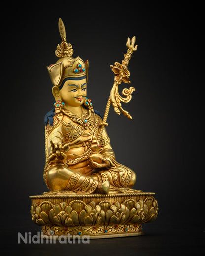 Guru Padmasambhava statue seated in meditation pose, adorned with ritual objects representing Tantric Buddhist symbolism.