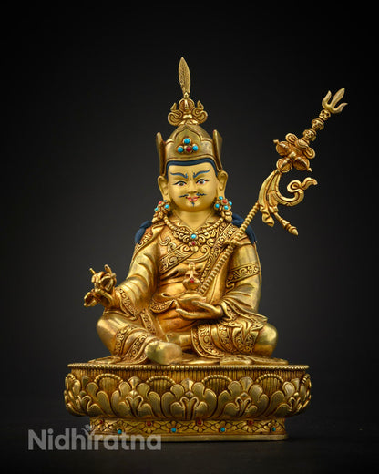 Elegant Vajrayana Buddhist statue of Guru Rinpoche with vibrant details and symbolic offerings in ceremonial attire.