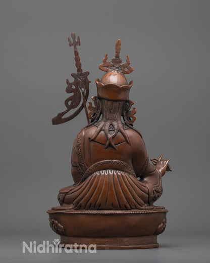 back view of oxidized copper guru rinpoche statue seated on throne with detailed robe