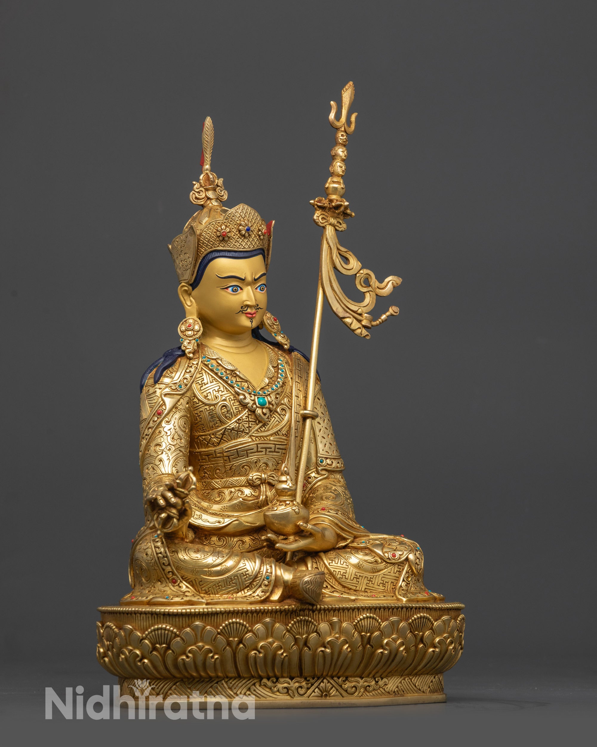 Side view Guru Rinpoche statue holding vajra and skull cup with vase and khatvanga staff
