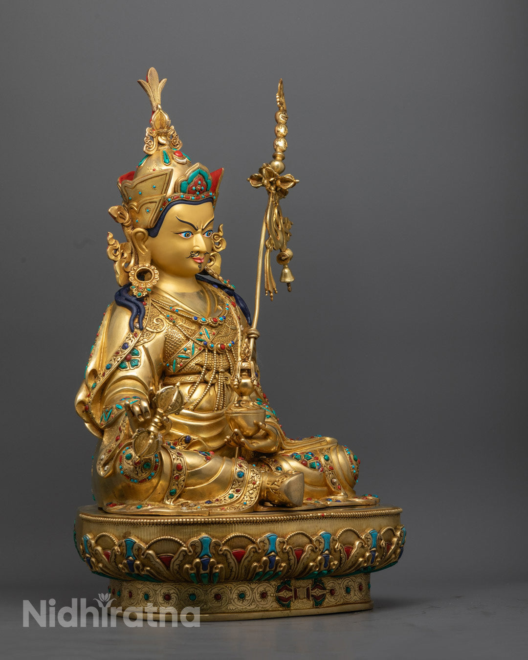 Padmasambhava statue showing symbolic hand gestures, flowing garments, and ritual objects with precise detailing