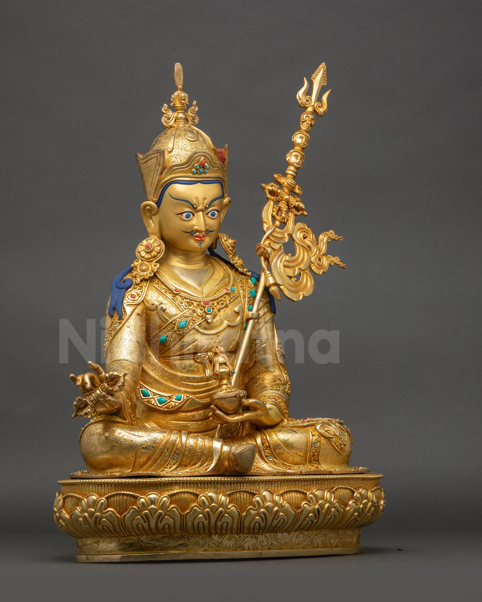 Right view of statue showing skull cup, dorje, trident, lotus hat, and detailed robe patterns