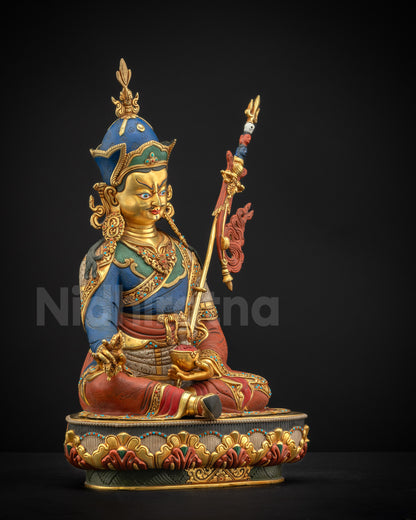 Right profile of Guru Rinpoche statue with khatvanga, skull cup, vajra, and lotus base.