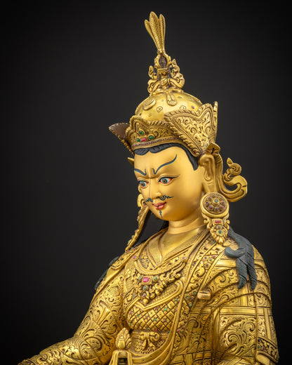 Side view close-up of Guru Rinpoche sculpture highlighting intricate kasaya robes and finely carved motif patterns