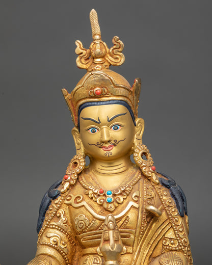 Guru Rinpoche Statue close up showing gold-painted face and floral filigree robes