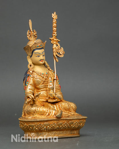 Guru Rinpoche sculpture side view, holding vajra and khatvanga, handcrafted in Nepalese copper with gold finish for meditation altars.