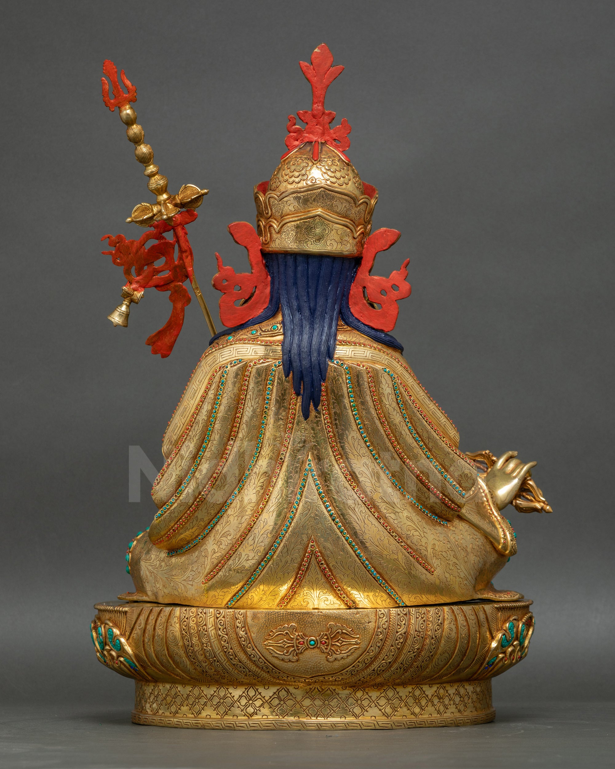 Guru Rinpoche statue back view showing 3D carvings and golden layers