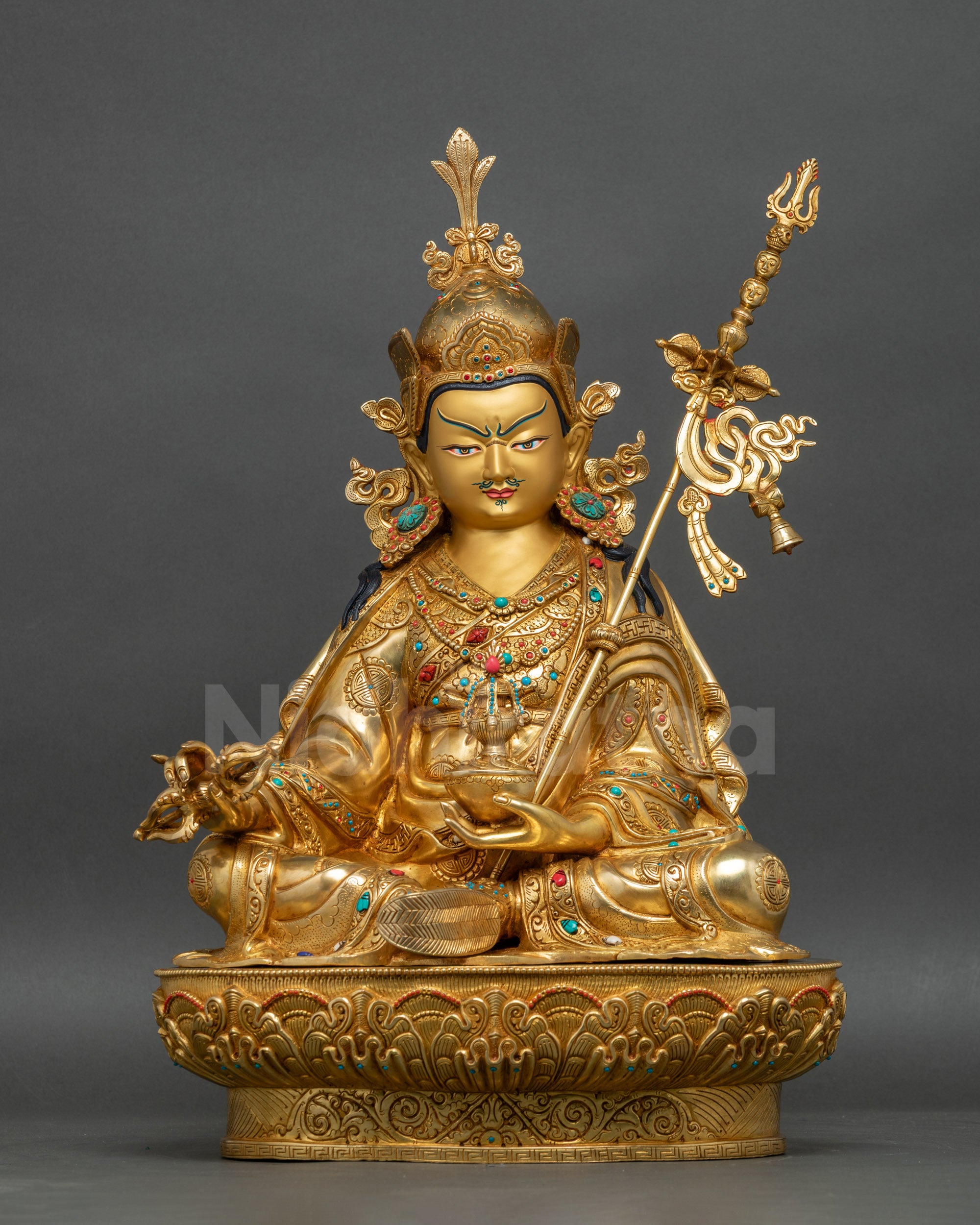 Guru Rinpoche statue front view with gold-painted face and lotus pedestal