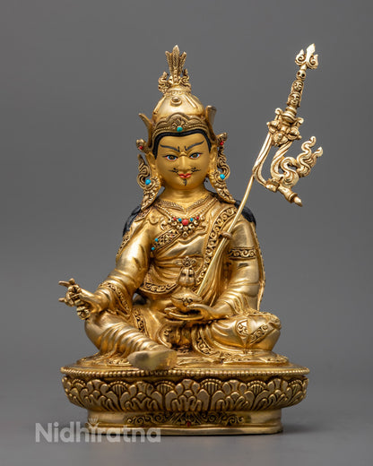 Guru Rinpoche statue holding vajra and skull cup, seated on lotus throne – symbol of enlightenment and protection in Tibetan Buddhism