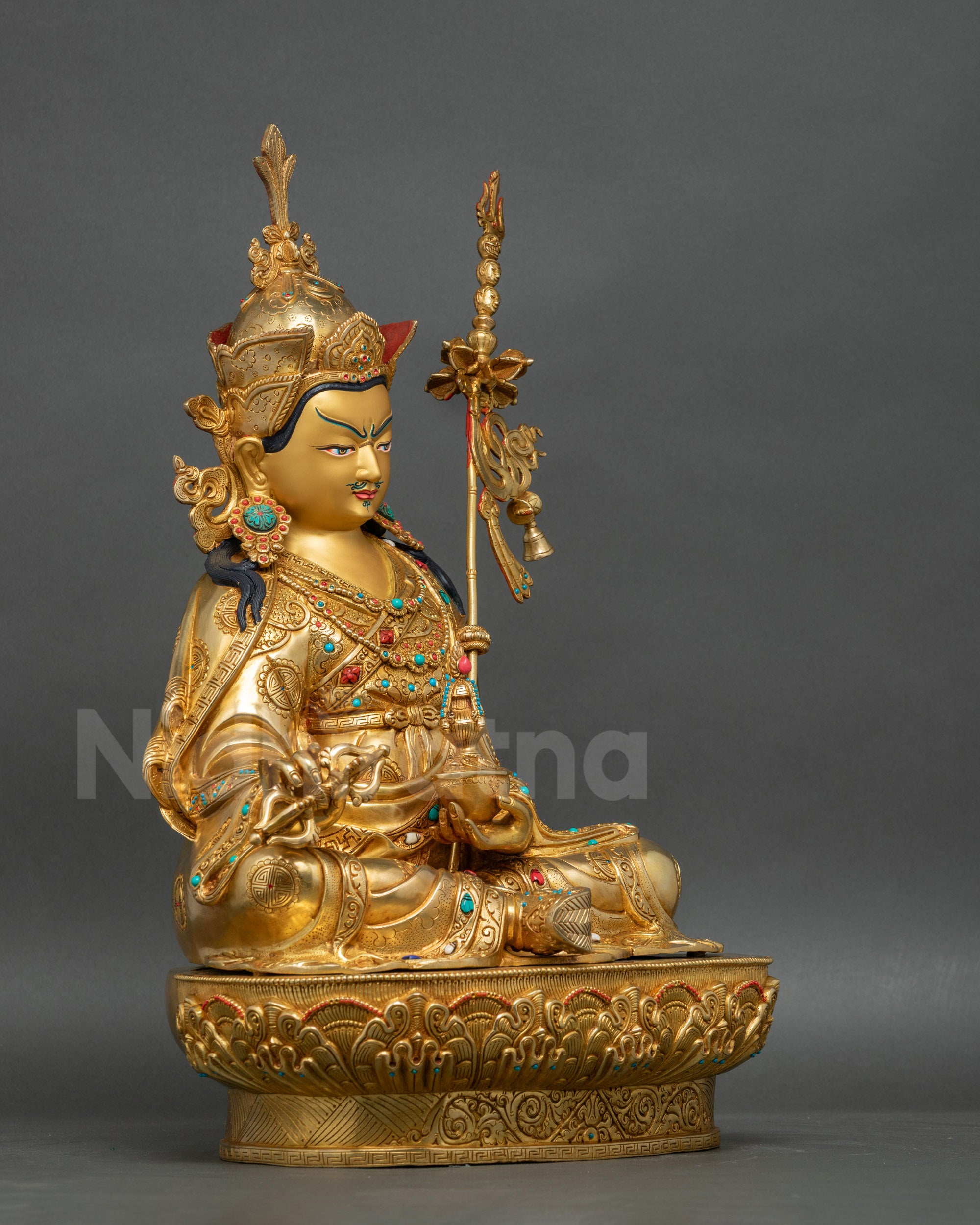Guru Rinpoche statue right side view with khatvanga staff and lotus base
