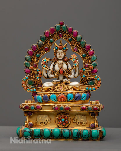 Hand-carved Chenrezig Statue seated on a lotus throne with four arms, symbolizing compassion in Tibetan Buddhism.