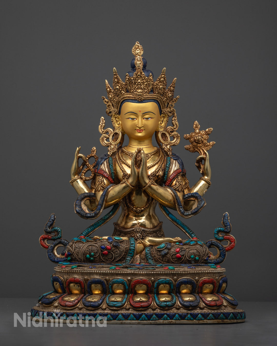 Hand-carved Chenrezig statue adorned with semi-precious stones and 24k gold fire-gilding, crafted by Nepalese artisans using the lost wax method.