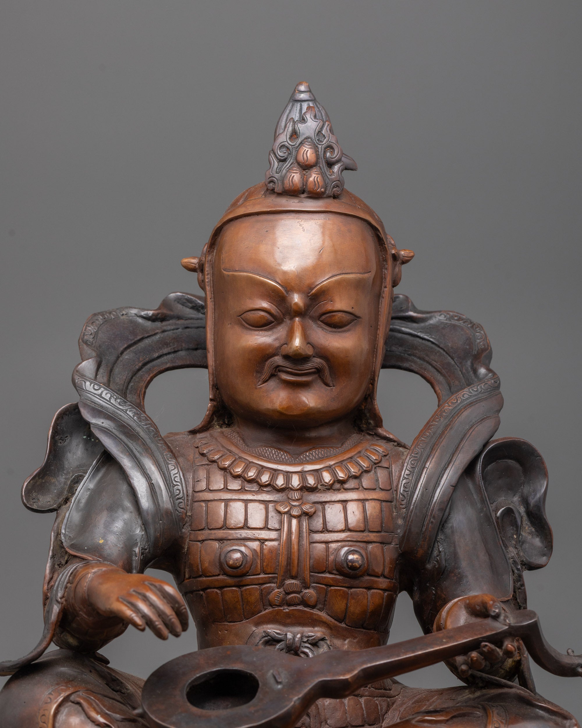 Hand-carved Dhrtarastra statue in oxidized copper seated on a plain base